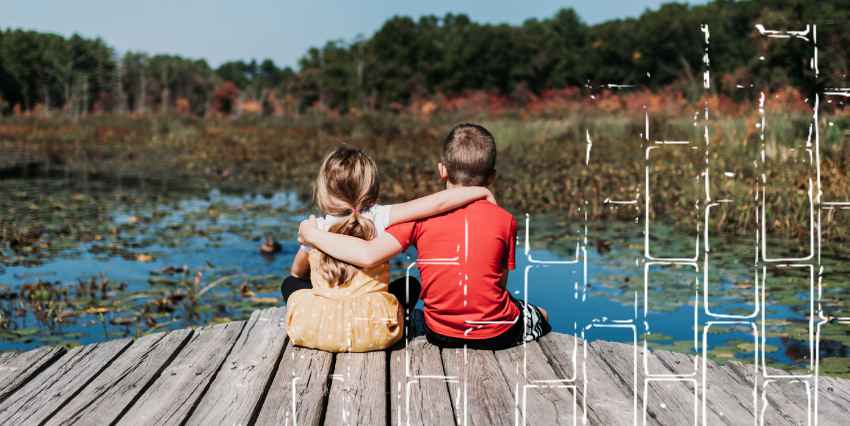 un niño y una niña abrazandoze sentados en un muelle de madera