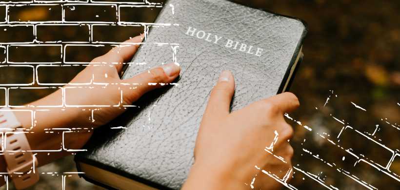 una persona aguantando una biblia negra, cerrada
