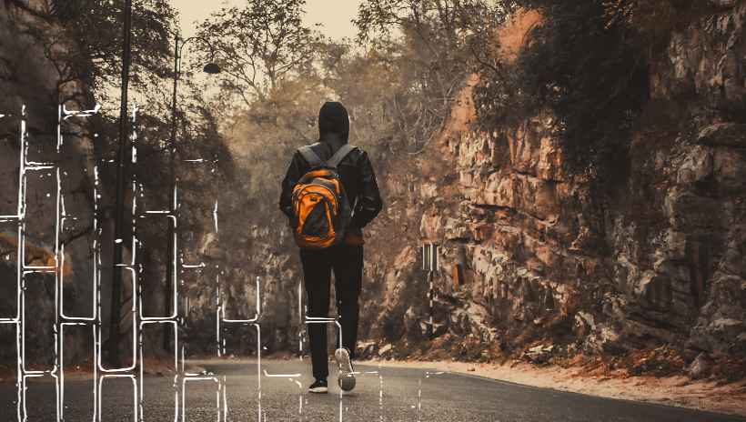 un hombre caminando en la calle con árboles a su lado, atardecer