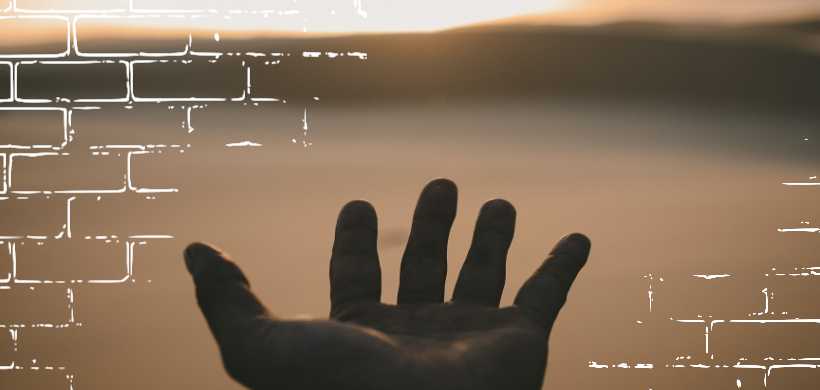 una mano extendida al cielo, en un atardecer