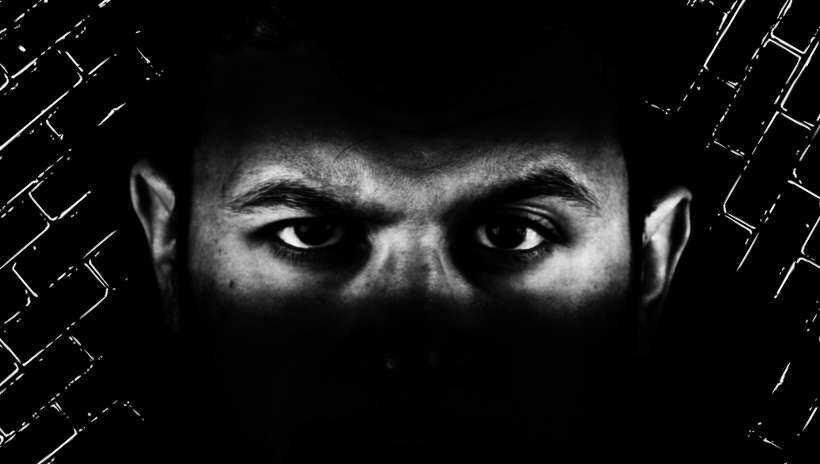 dos ojos de un hombre rodeado de negro (oscuridad)