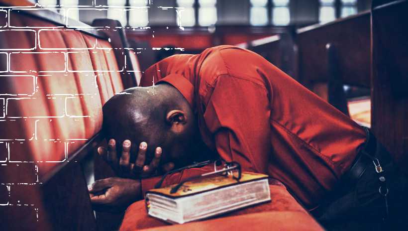 cun hombre arrodillado y orando, con una biblia a su lado