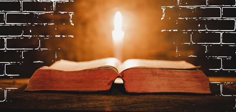 una biblia abierta con una vela en el centro