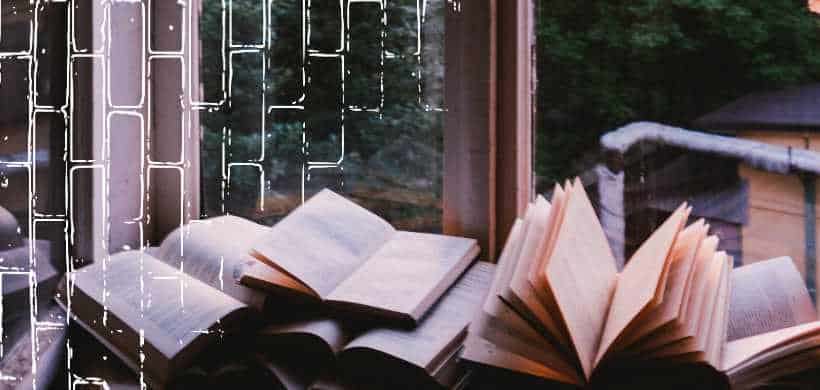 muchos libros abiertos alfrente de una ventana