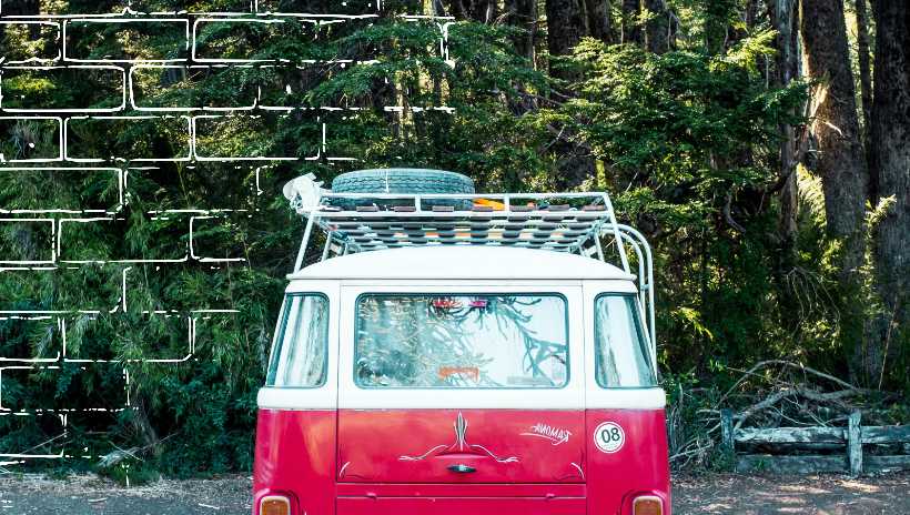 un carro rojo rodeado de un bosque